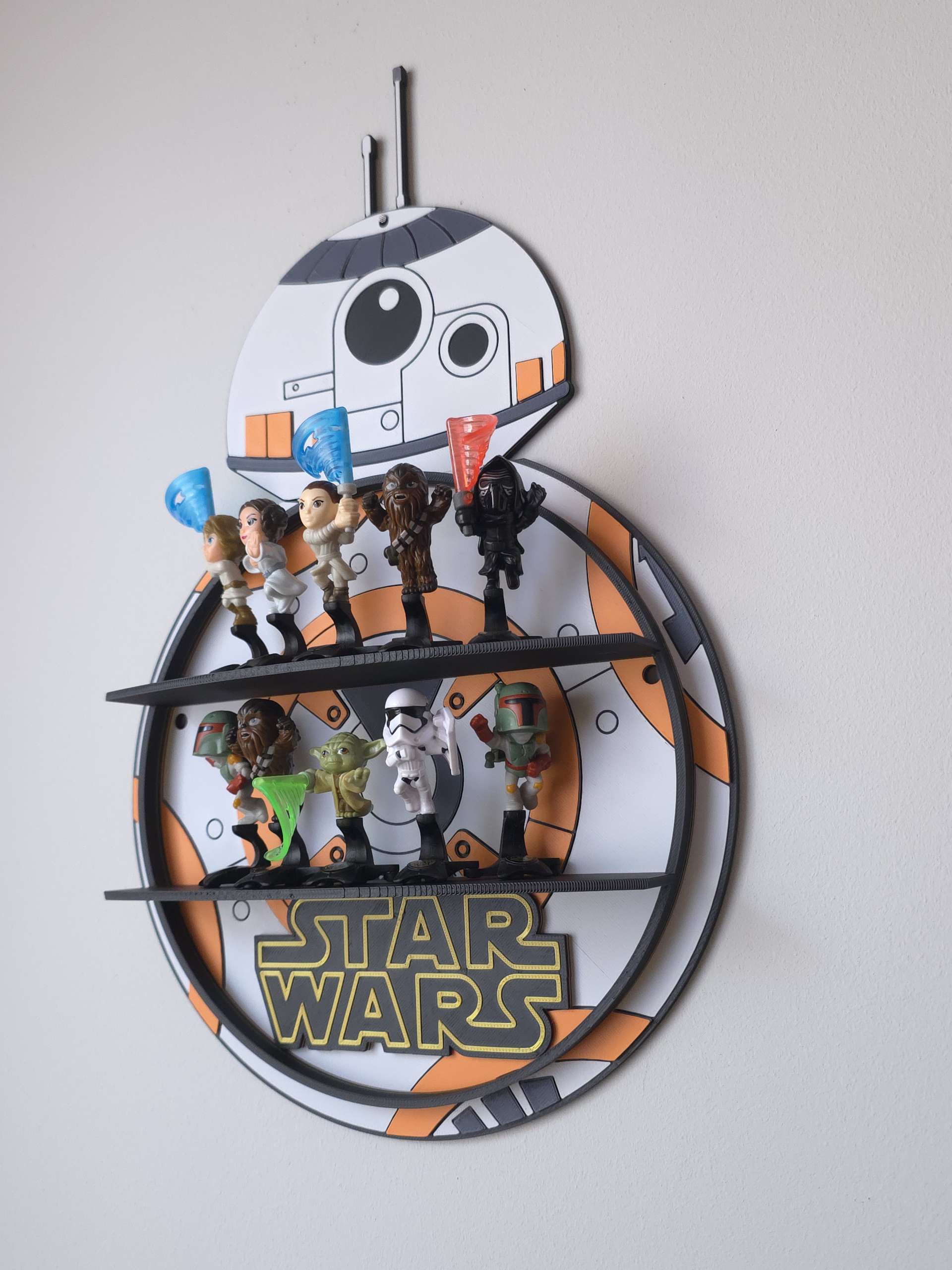 Boczny profil półki BB-8 Star Wars zamontowanej na ścianie z ułożonymi figurkami kolekcjonerskimi z Kinder Niespodzianki.